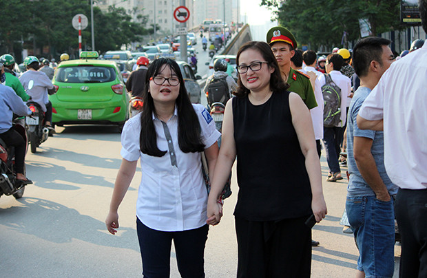 Phụ huynh nắm chặt tay thí sinh ở điểm trường THPT chuyên Hà Nội - Amsterdam để động viên con sau khi hoàn thành xong bài làm môn Toán.