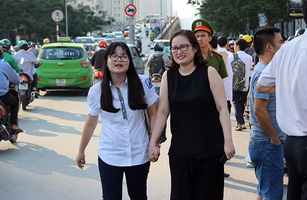 Phụ huynh nắm chặt tay thí sinh ở điểm trường THPT chuyên Hà Nội - Amsterdam để động viên con sau khi hoàn thành xong bài làm môn Toán.