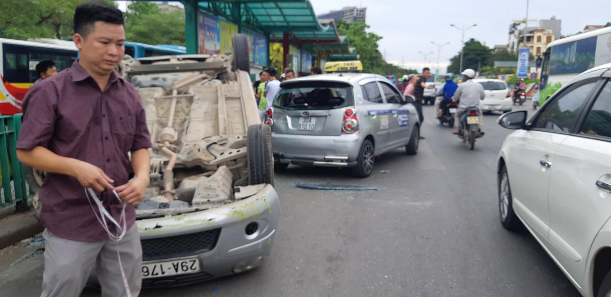 Sau khi đâm vào hàng rào chắn ở điểm trung chuyển xe buýt, ô tô con lao vào xe taxi rồi lật chổng vó trên đường.
