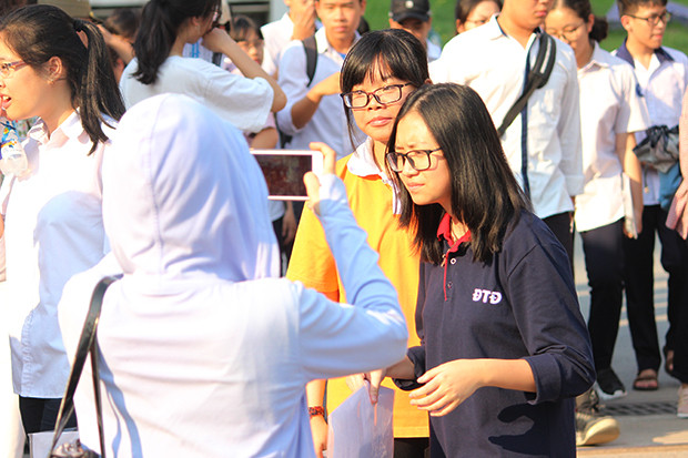 Dù thời tiết rất nắng nóng, nhưng một phụ huynh vẫn cố gắng nán lại trước cổng trường THPT chuyên Hà Nội - Amsterdam để chụp cho con bức hình kỷ niệm.