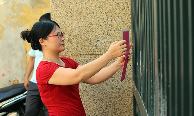 Phụ huynh cố gắng chụp lại khoảnh khắc tại điểm thi để làm kỷ niệm.