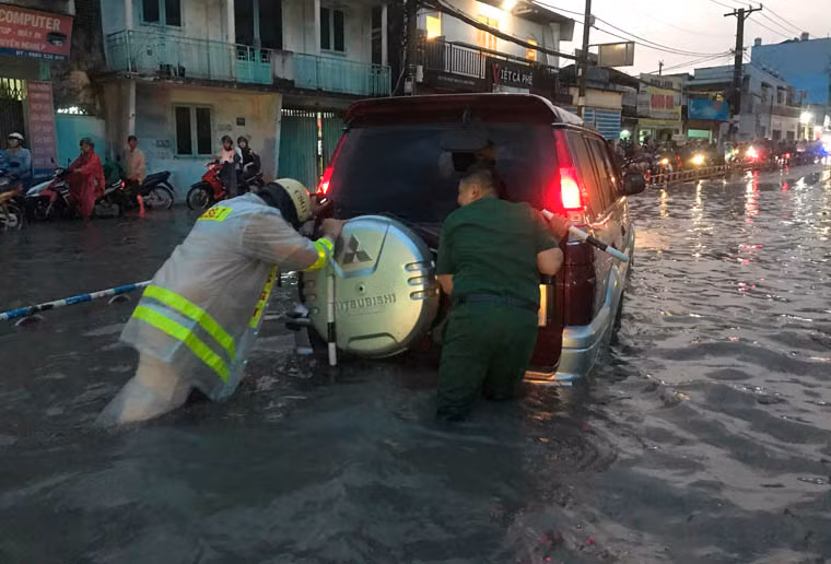 CSGT và Thanh niên xung phong giúp người dân đưa phương tiện bị hư ra khỏi vùng ngập nặng.
