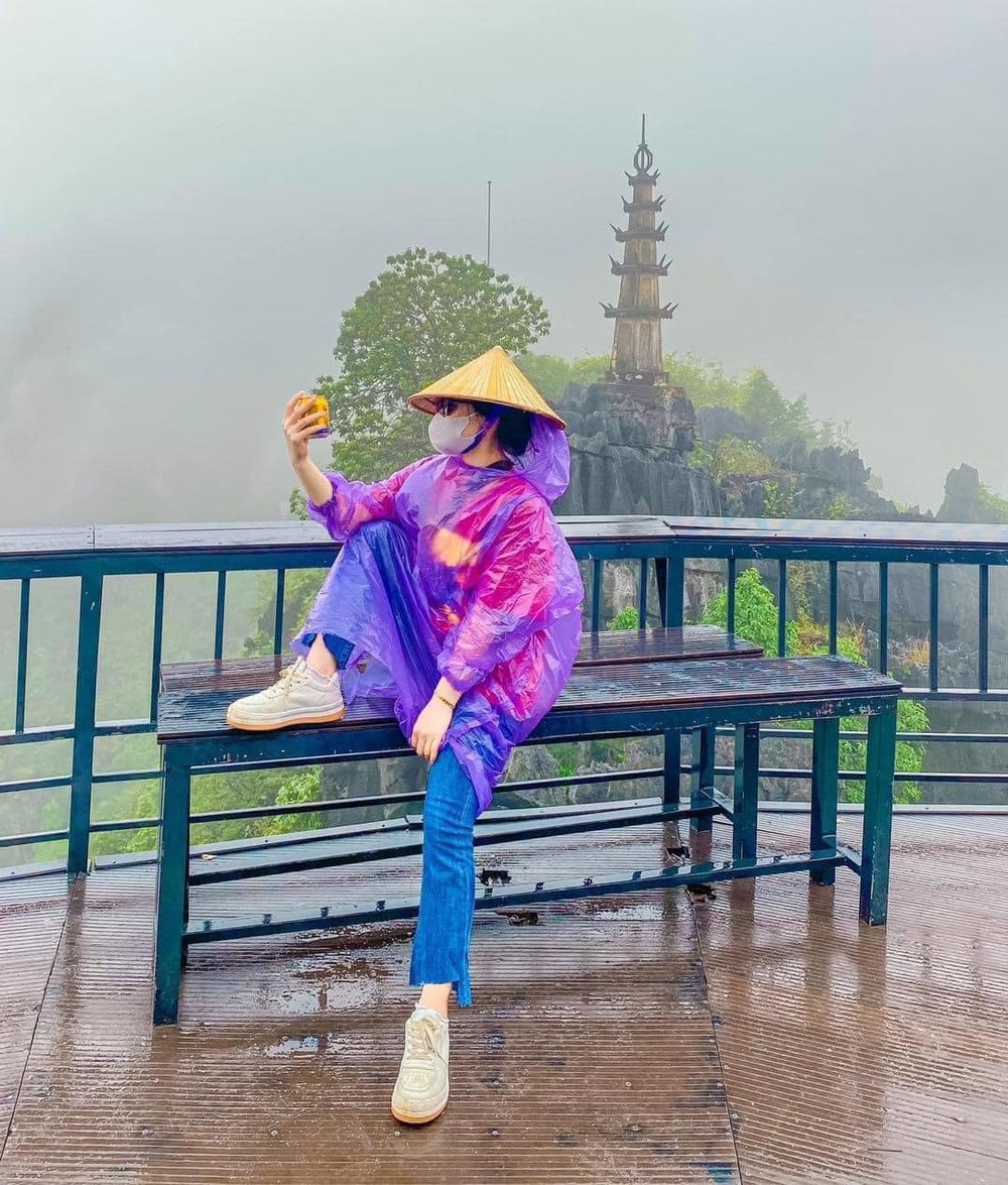 Để chuyến đi không uổng phí, đôi bạn trẻ vẫn mặc áo mưa và chụp ảnh tại các điểm check-in có tiếng.