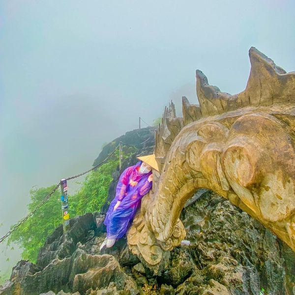 Trong loạt khoảnh khắc check-in Ninh Bình, hai cô bạn mặc áo phông, quần bò kết hợp với giày thể thao. Tuy nhiên, bên ngoài người thì mặc chiếc áo mưa vàng, người thì mặc chiếc áo mưa tím.