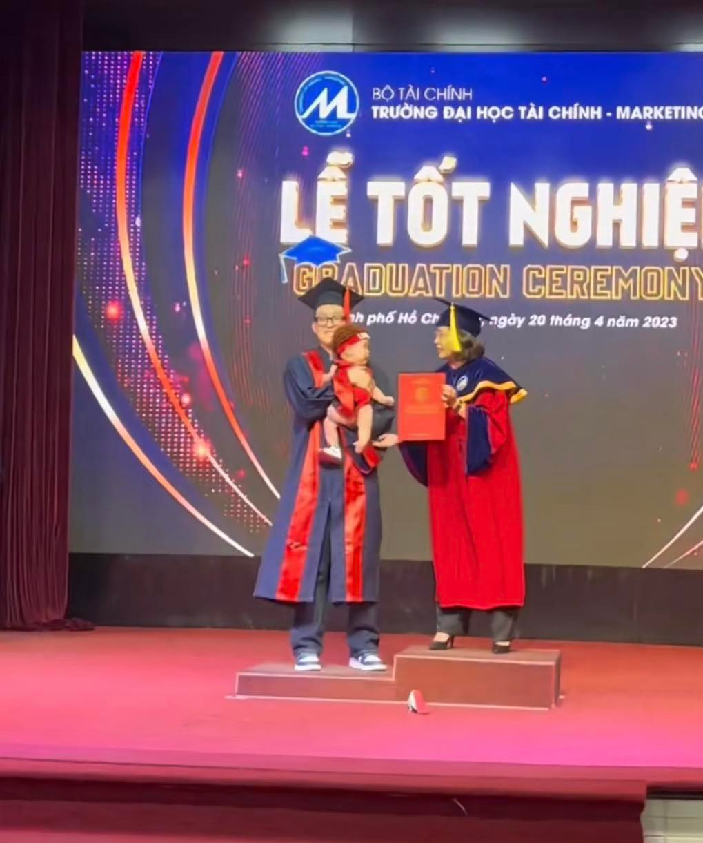 Có thể thấy, em bé còn khá nhỏ, nhóc tỳ này cũng được bố diện trang phục đẹp đẽ, ngồi ngoan trong vòng tay bố để lên nhận tấm bằng tốt nghiệp.