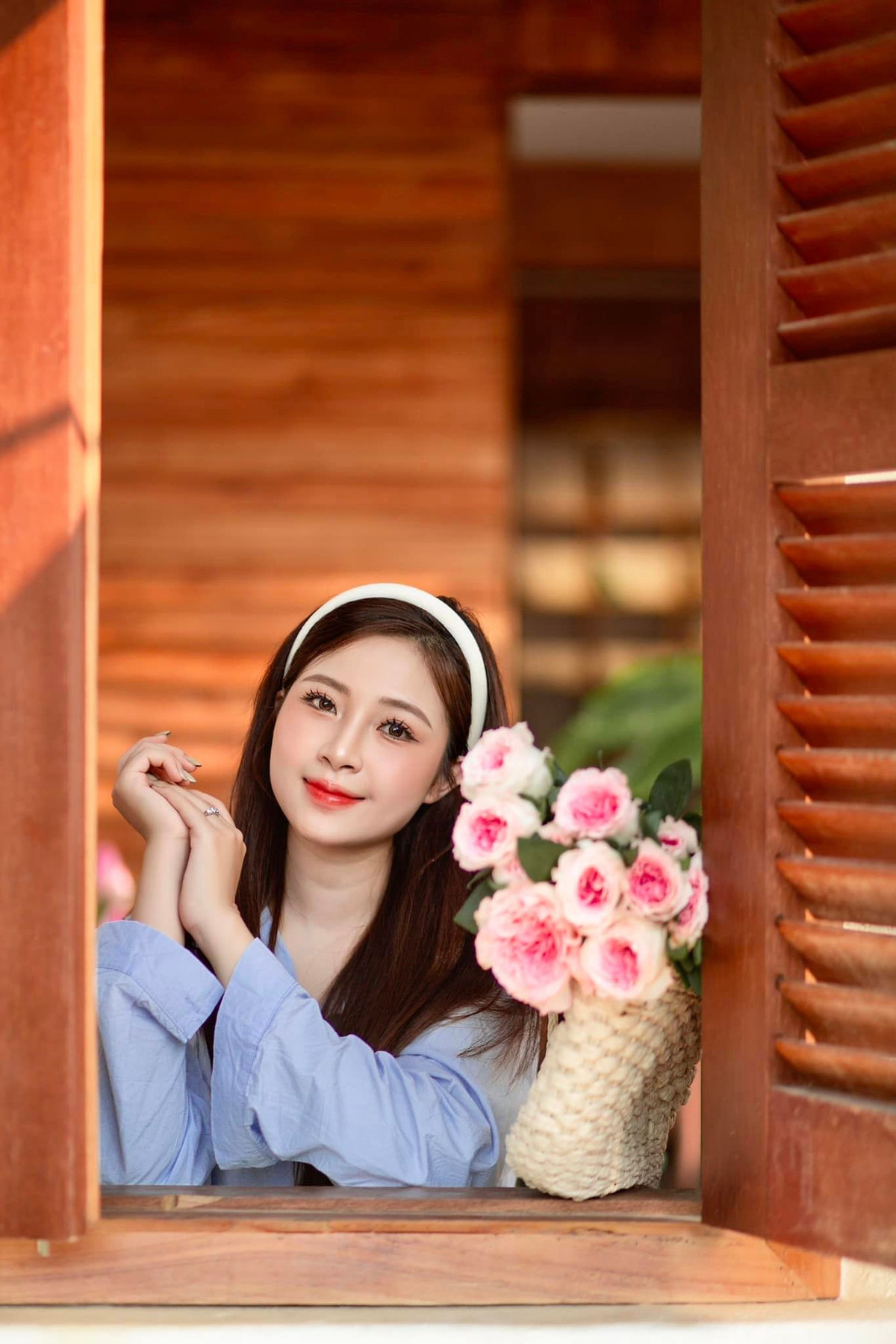 Diện áo sơ mi màu xanh dương, đeo chiếc băng đô màu trắng cùng bó hoa, vợ Phan Văn Đức xinh đẹp và thuần khiết.