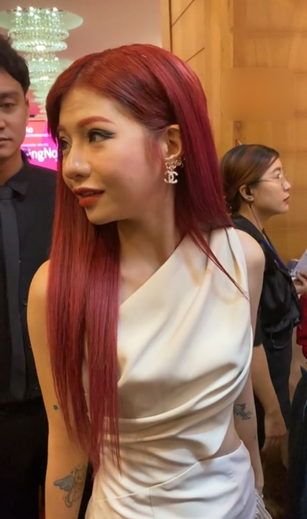 Nữ TikToker diện một thiết kế đơn giản, mái tóc màu đỏ cháy giúp cô nàng nổi bật giữa sự kiện. Đây cũng là lần hiếm hoi từ khi công khai dao kéo cô khoe trọn gương mặt của mình.
