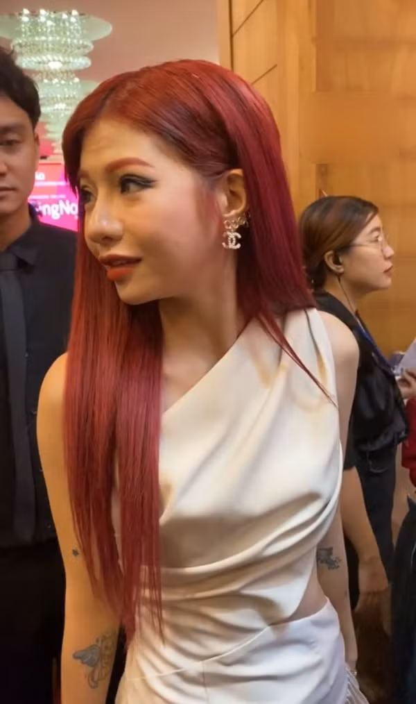 Nữ TikToker diện một thiết kế đơn giản, mái tóc màu đỏ cháy giúp cô nàng nổi bật giữa sự kiện. Đây cũng là lần hiếm hoi từ khi công khai dao kéo cô khoe trọn gương mặt của mình.