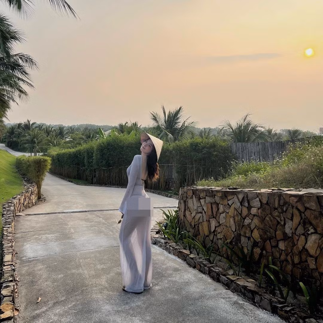 Cô nàng diện áo khoác mỏng tang, xuyên thấu dài đến chân, việc đội thêm nón lá khiến cô bị hiểu nhầm là mặc áo dài phản cảm.
