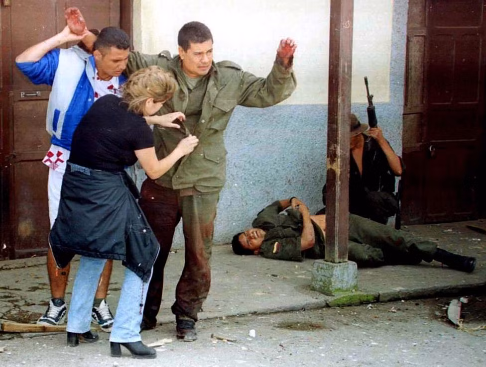 Bị FARC thúc ép, hai dân thường đang lục soát một cảnh sát Colombia ở tỉnh Tolima hồi tháng 12/1999.