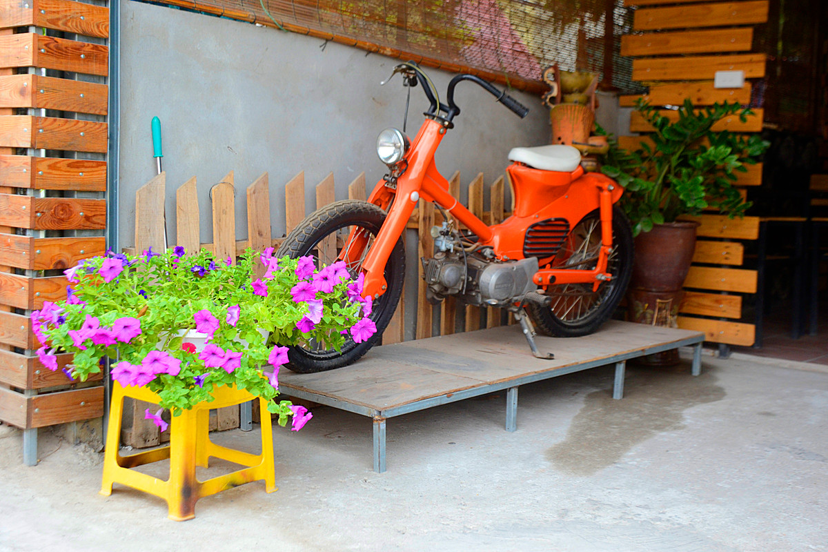 Góc bên trái ngôi nhà được trang trí khá bắt mắt bởi chiếc xe màu cam cũ kỹ.
