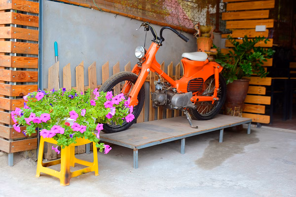 Góc bên trái ngôi nhà được trang trí khá bắt mắt bởi chiếc xe màu cam cũ kỹ.