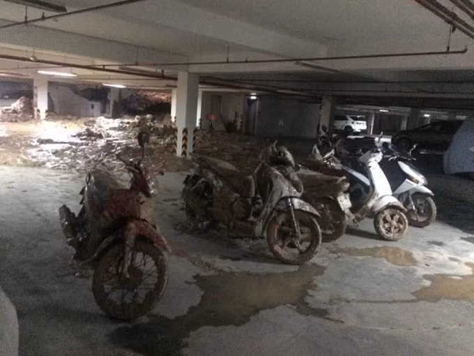 Do tường vỡ trong lúc mưa nên lượng bùn, đá, đất nhão từ công trình tràn vào tầng hầm kế bên. Lực đẩy của bùn, đất đã hất hàng chục xe máy ra nhiều mét, gần 20 xe máy đã bị chôn trong bùn, một số xe hơi bị bùn tràn vào nửa thân xe. Rất may thời điểm sập, không có người trong hầm. Ảnh: phapluatplus.vn.. Ảnh: phapluatplus.vn.