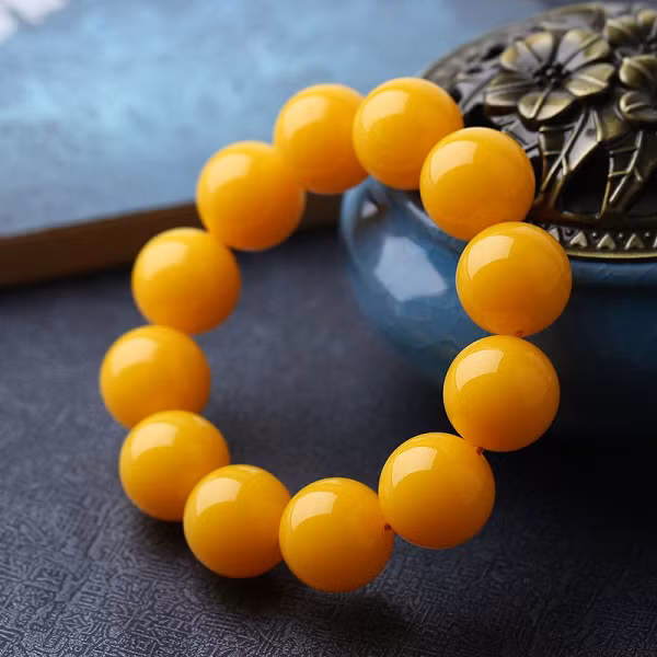 Nguyên nhân là bởi trong quá trình hình thành, nhựa chảy từ cây đã cuốn theo nhiều không khí. Đến lúc cứng lại, những bọt khí nhỏ li ti được tạo thành. Chính những bọt khí này đã tạo nên màu sắc vàng đục như sáp .