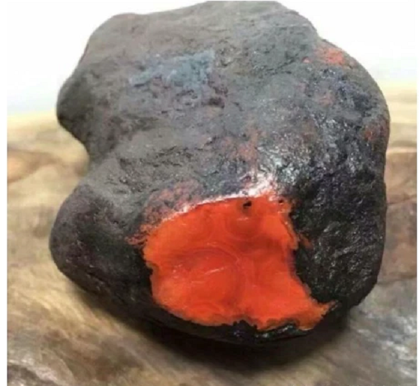 Thật bất ngờ, sau khi được xẻ ra, hòn đá này bên ngoài màu đen nhưng bên trong ruột lại đỏ như máu. Hóa ra đây là 1 khối mã não Nam Hồng thô cực kỳ hiếm.