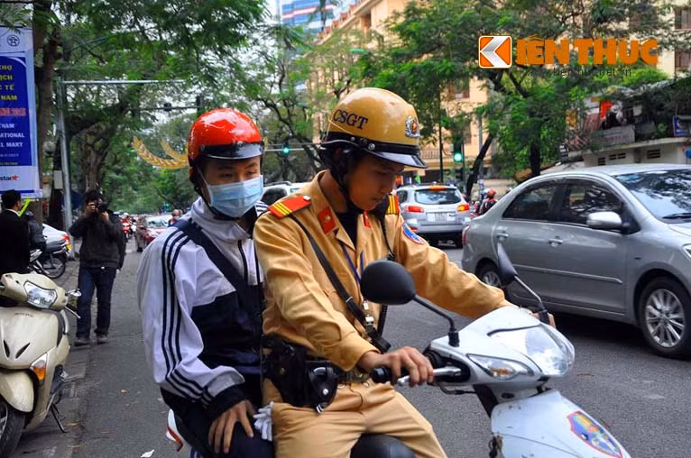 Với những học sinh bị giữ xe, nếu không có người thân tới đều được các CSGT chở tới trường để tránh muộn giờ học. Trong ảnh là một học sinh trường Đinh Tiên Hoàng, bị các chiến sĩ CSGT tạm giữ xe và dùng xe của đội CSGT đưa đến trường.