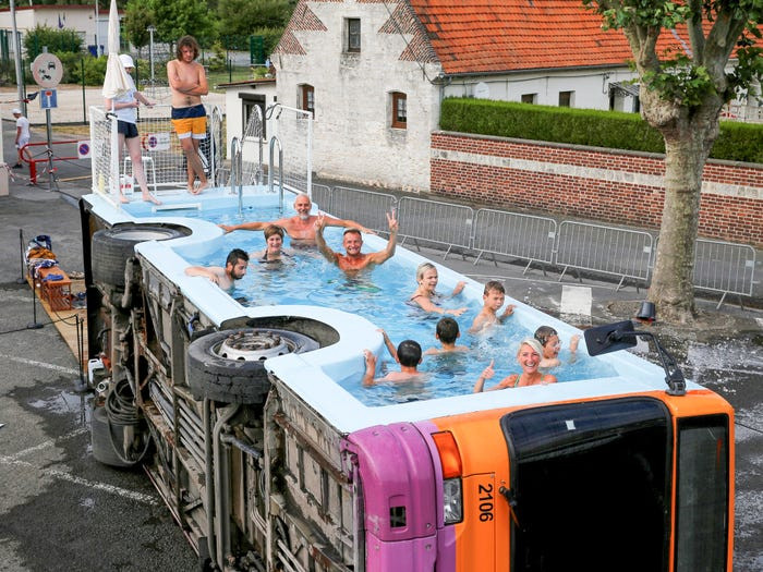 Mọi người tắm trong một chiếc xe buýt đã ngừng hoạt động có tên "le bus piscine" - một tác phẩm nghệ thuật của nghệ sĩ người Pháp Benedetto Bufalino ở Gosnay gần Bethune, Pháp.
