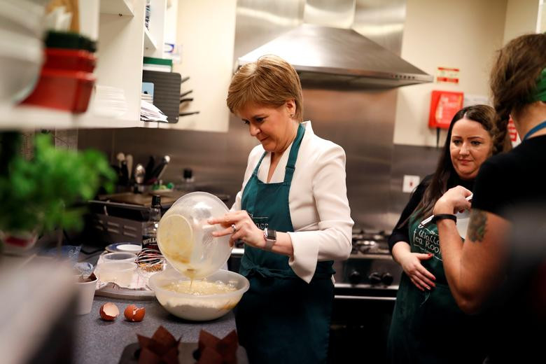 Lãnh đạo Đảng Dân tộc Scotland Nicola Sturgeon vào bếp nướng bánh khi bà vận động cử tri tại Lanark, Scotland, ngày 9/12. Ảnh: Reuters.