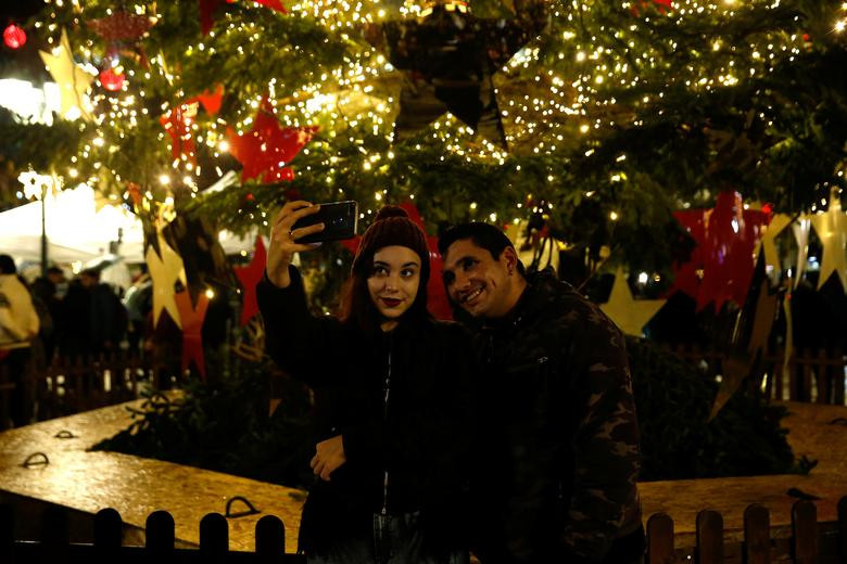 Người phụ nữ chụp ảnh "tự sướng" trước cây thông Noel ở Athens, Hy Lạp, ngày 10/12.