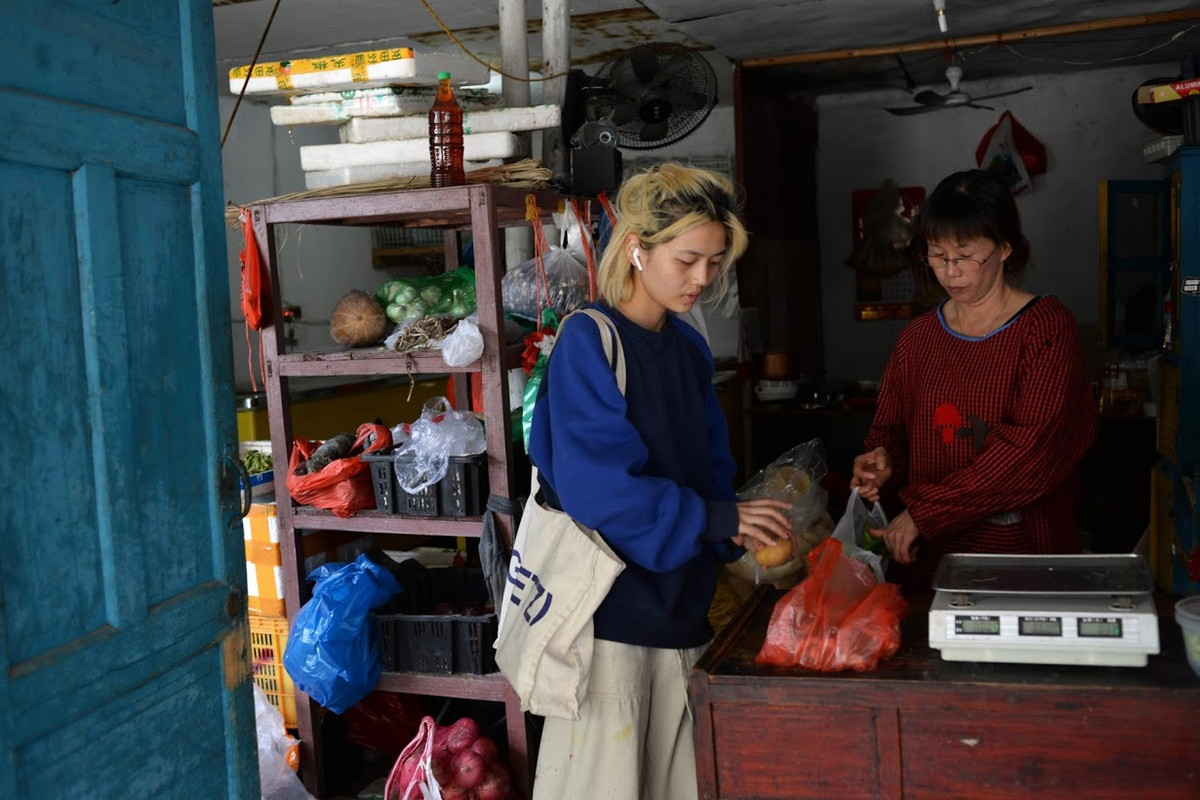 Nhà quay phim tự do Chen Yan cho hay, ban đầu cô dự định chỉ ở lại một tuần, nhưng cuối cùng cô đã ở lại đây một tháng. "Tôi sống trong một căn phòng vừa gần gũi với thiên nhiên nhưng vẫn kết nối với thế giới bên ngoài. Tôi ở lại đây lâu hơn dự định vì tôi muốn tiếp tục tận hưởng cảm giác thoải mái đó", cô gái 24 tuổi chia sẻ. Ảnh: Chen mua rau tại một cửa hàng.