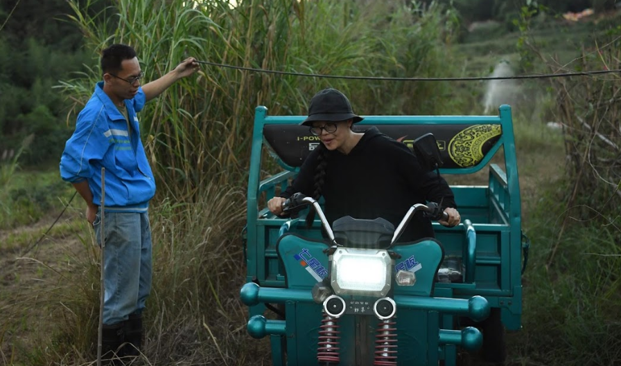 Xing Zhen lái xe đi qua một trang trại trong làng.