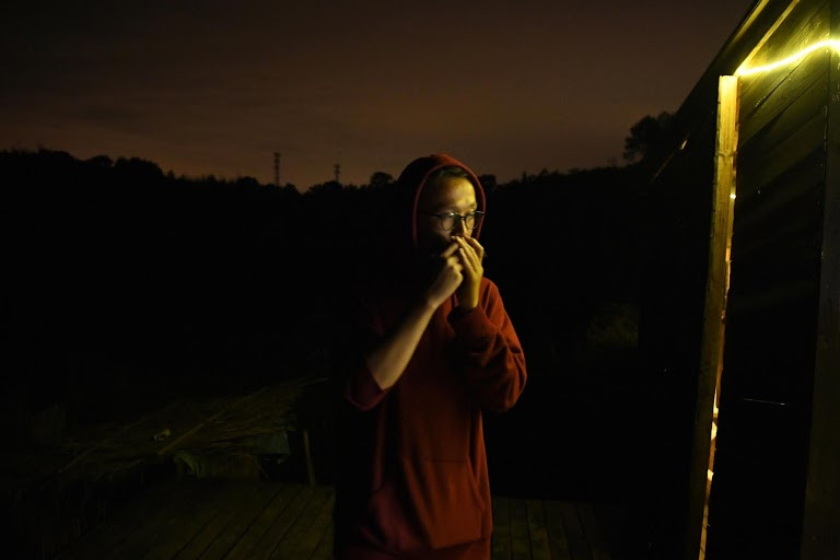 Yang Junhao chơi kèn harmonica trong một bữa tiệc tối của cộng đồng AnotherCommunity.