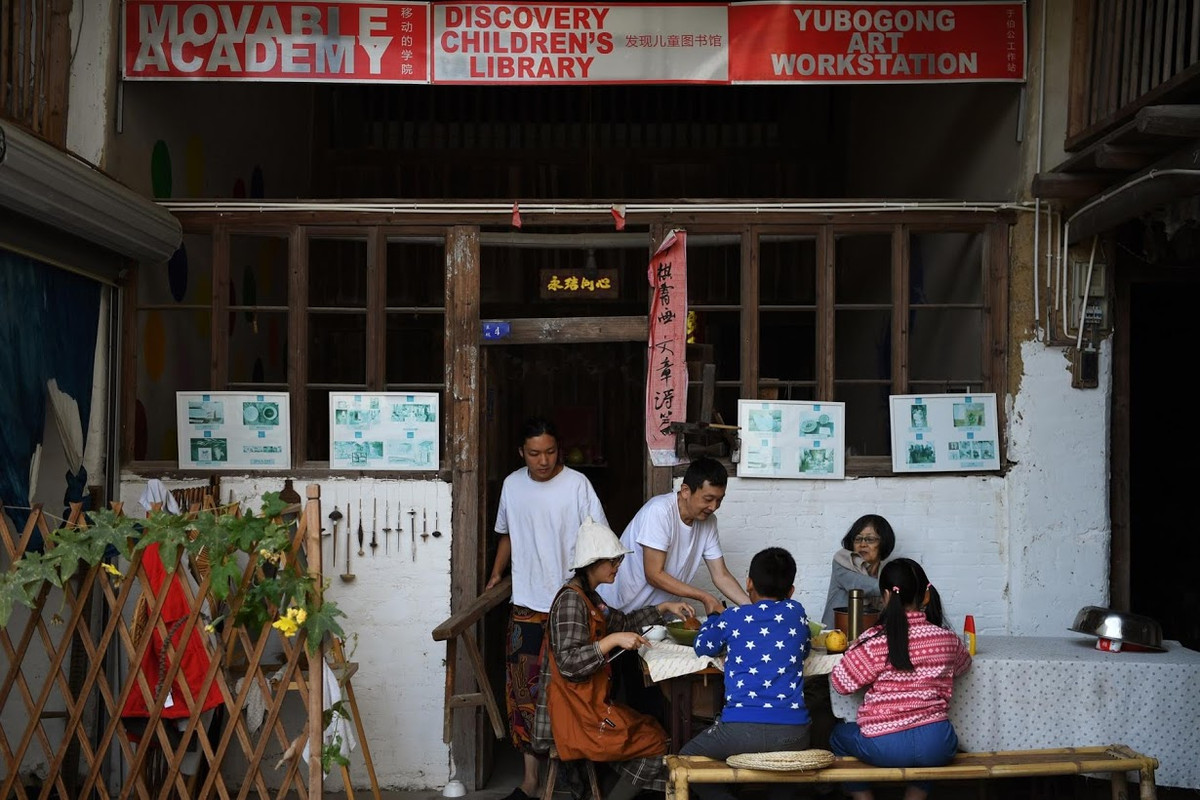 Tang Guanhua, Xing Zhen, cha mẹ của Zhen và học sinh của cô ăn trưa trong ngôi làng đặc biệt này.