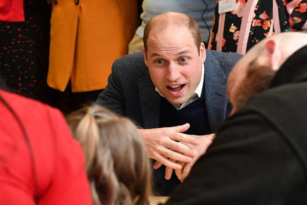 Hoàng tử William chăm chú lắng nghe các em nhỏ.