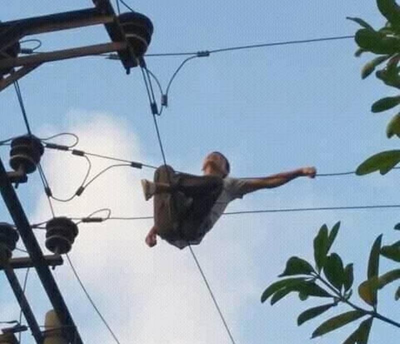 Người đàn ông vắt vẻo trên dây điện.