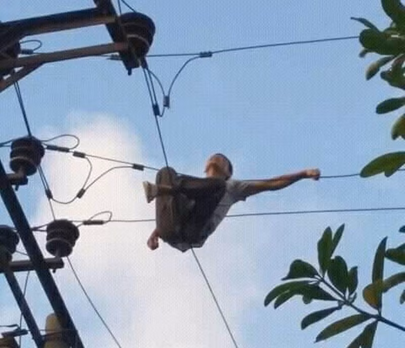Người đàn ông vắt vẻo trên dây điện.