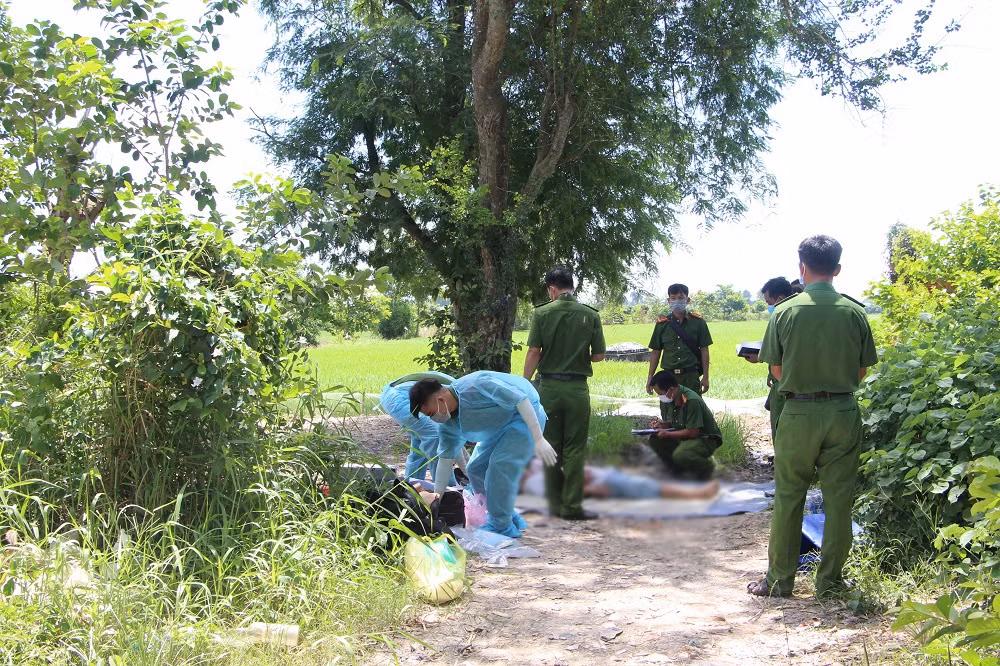 Địa điểm phát hiện tử thi cạnh một vườn xoài rộng ở vùng dân cư thưa thớt, vắng người qua lại. Khám nghiệm ban đầu cho thấy, trên người nạn nhân có tới 15 vết gồm vết đâm, chém chí mạng. Cạnh đó có một con dao dài khoảng 30cm, bề ngang khoảng 5cm ở tư thế cắm đứng xuống đất, trên lưỡi dao còn dính chất màu nâu đỏ, nghi là máu. Cách đó không xa có một chiếc xe máy đổ nghiêng về bên trái, đang trong tình trạng mở khóa, trên xe dính nhiều máu, tại nền đất không thấy dấu vết phanh xe, đồng thời có dấu vết trượt chân và một chuỗi vòng đeo tay dính máu.. (Ảnh Thanh Niên) 