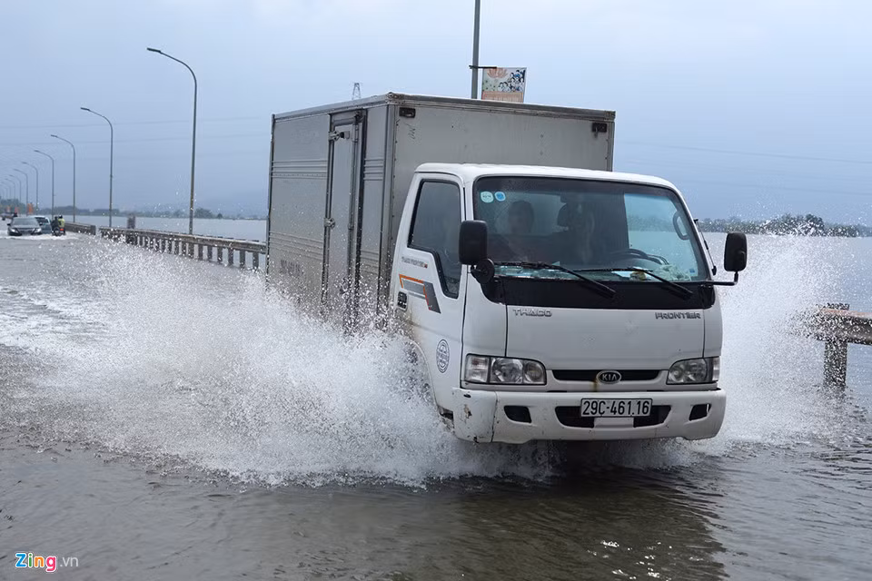 Hầu hết phương tiện lưu thông trên đường này phải tăng ga vọt qua để tránh nước tràn vào máy.