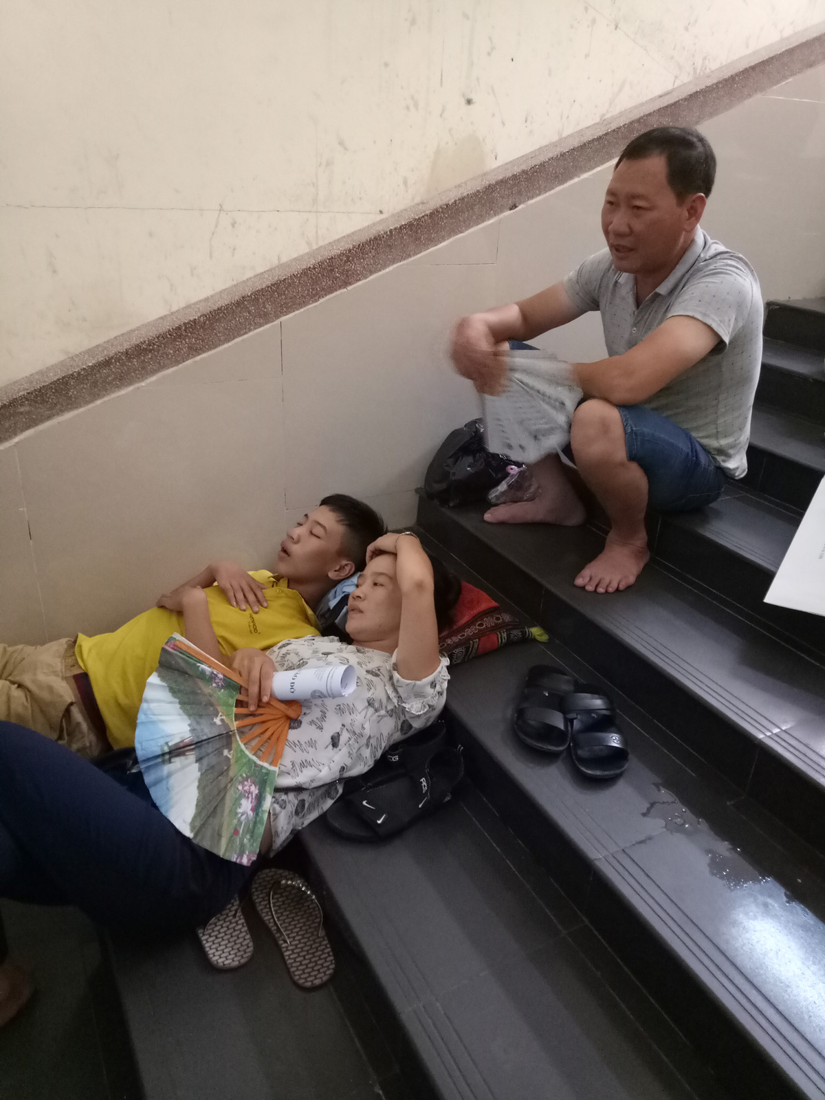 Mặc kệ đau lưng, chỉ cần chỗ nào có không gian thoáng hơn là người nhà, bệnh nhân tranh thủ kê dép, kê gối để nằm cho đỡ mệt.