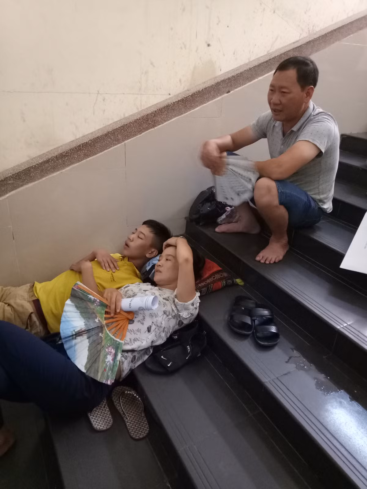 Mặc kệ đau lưng, chỉ cần chỗ nào có không gian thoáng hơn là người nhà, bệnh nhân tranh thủ kê dép, kê gối để nằm cho đỡ mệt.