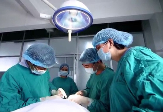Các bác sỹ tiến hành phẫu thuật bao quy đầu cho bệnh nhân. Ảnh: Lao động
