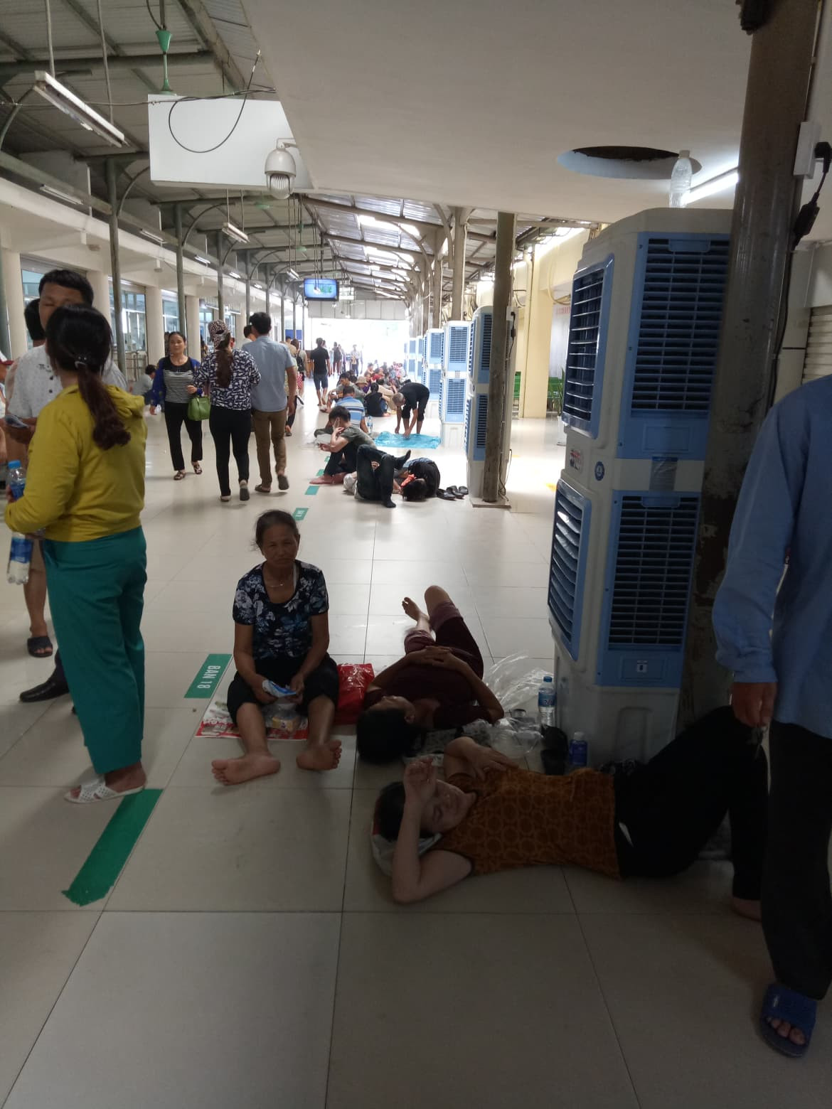 Khu vực tiếp nhận bệnh nhân ban đầu trở thành nơi "nghỉ ngơi" của những bệnh nhân lớn tuổi. Một nữ bệnh nhân quê Nghệ An cho biết: Nắng nóng khiến bà khó thở, sợ bị ảnh hưởng tới bệnh tim nên bà bắt xe ca ra Hà Nội từ đêm qua. Buổi sáng khám xong, đợi đến chiều mới có kết quả. Trời quá nắng, lại thiếu ngủ nên bà nằm ngủ luôn tại sảnh. 