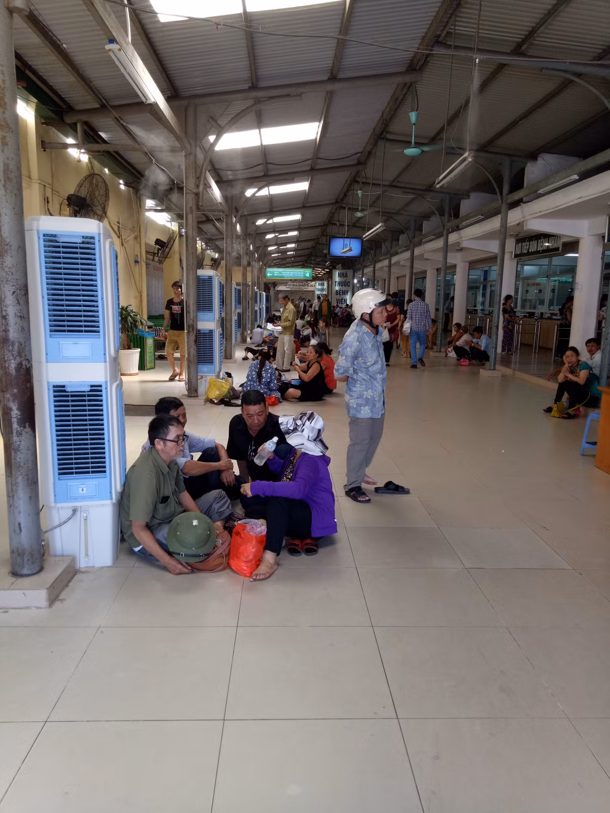 Vã hết cả mồ hôi nên cứ chỗ nào có quạt trần, quạt máy và quạt điện, bệnh nhân và người nhà lại túm tụm hưởng tí gió mát.