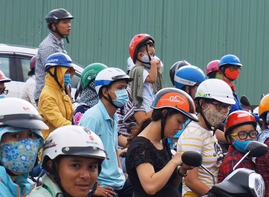 Một người đàn ông cùng em nhỏ tỏ ra lo lắng phải đứng dậy để quan sát vì phía trước kẹt cứng.