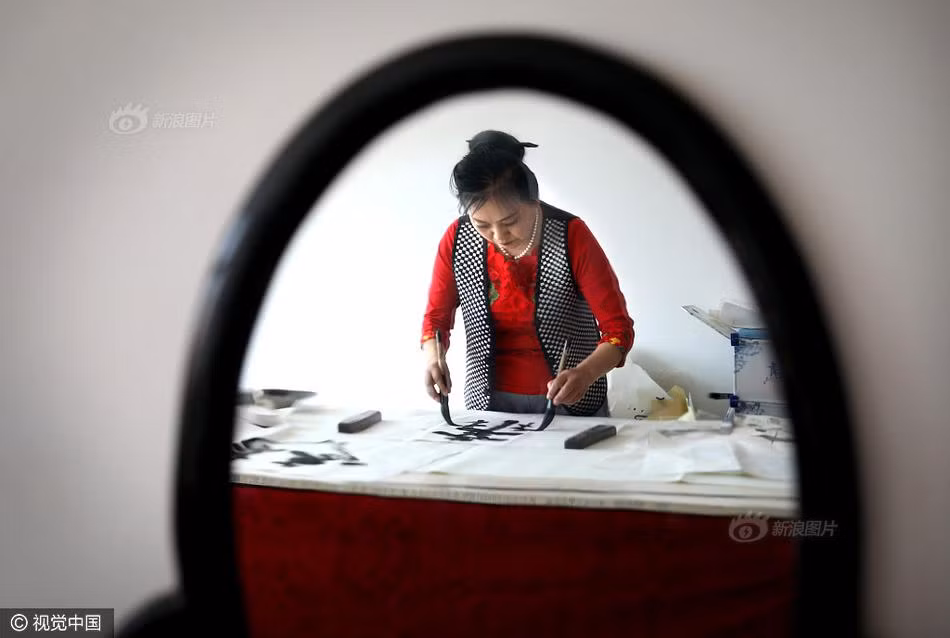 Không chỉ có mái tóc dài kỷ lục, bà Cao Tuấn Anh còn gây ấn tượng mạnh ở khả năng thư pháp của mình. Bà có thể cùng lúc viết chữ bằng cả tay phải và tay trái, chẳng khác nào cao thủ võ lâm được miêu tả trong những bộ truyện kiếm hiệp nổi tiếng của nhà văn Kim Dung. (Nguồn Sina)