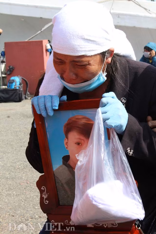 Cầm sẵn chiếc áo tang, mẹ của thợ máy Lê Văn Ba (SN 1990, quê Thanh Hóa) gục xuống bên di ảnh con trai.