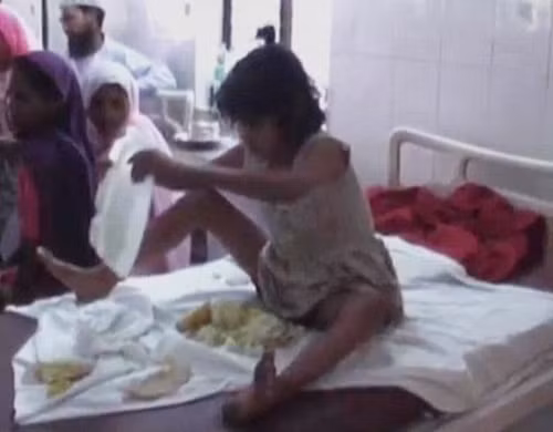 Trong ảnh là cảnh cô bé người rừng đang tập dùng tay để ăn cơm như người bình thường. (Nguồn Sina)