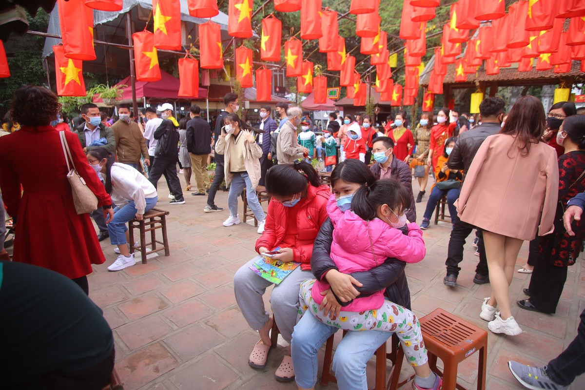 Ông đồ và sĩ tử đeo khẩu trang, đứng giãn cách khi cho chữ, xin chữ, kính chắn giọt bắn được đặt trên bàn cho chữ để phòng Covid-19.