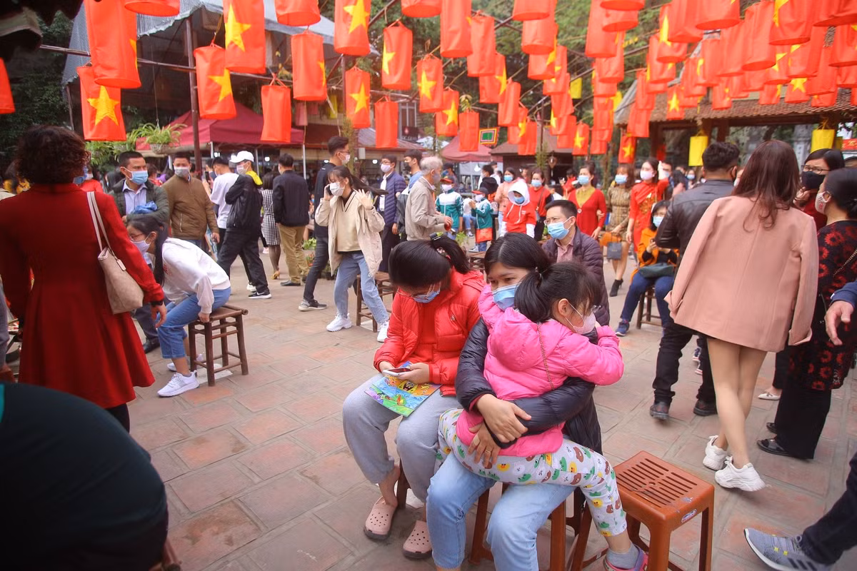 Ông đồ và sĩ tử đeo khẩu trang, đứng giãn cách khi cho chữ, xin chữ, kính chắn giọt bắn được đặt trên bàn cho chữ để phòng Covid-19.