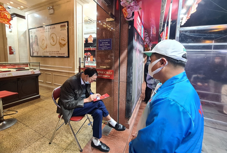 Nhân viên cửa hàng vàng ghi số giao dịch cho khách.