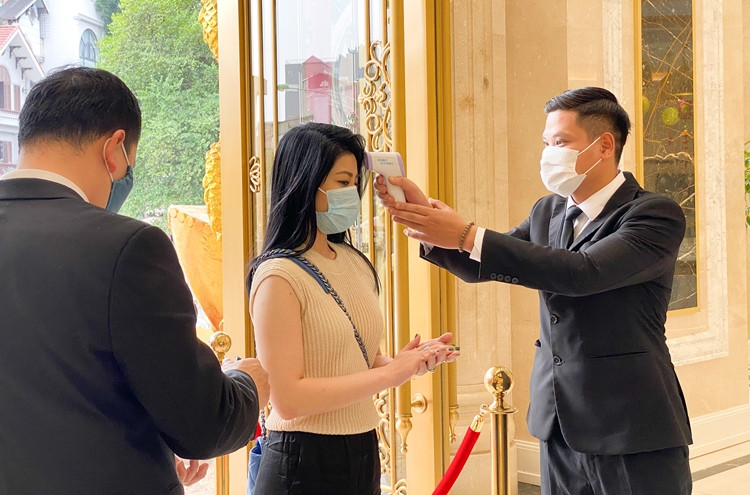 Khách khi đến giao dịch sẽ được nhân viên của DOJI hướng dẫn đeo khẩu trang, đo thân nhiệt, xịt khử khuẩn tay từ cửa ra vào.