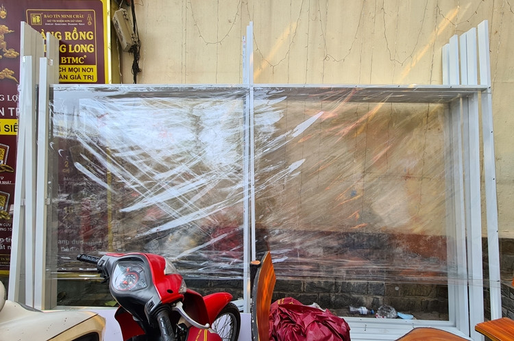 Trước ngày vía Thần Tài, cửa hàng Bảo Tín Mạnh Hải nằm trên đường Trần Duy Hưng (Hà Nội) đã chuẩn bị vách mica, cao trên 2m, chia thành các làn và đánh dấu vị trí đứng giãn cách cho khách đến giao dịch để phòng chống COVID-19.