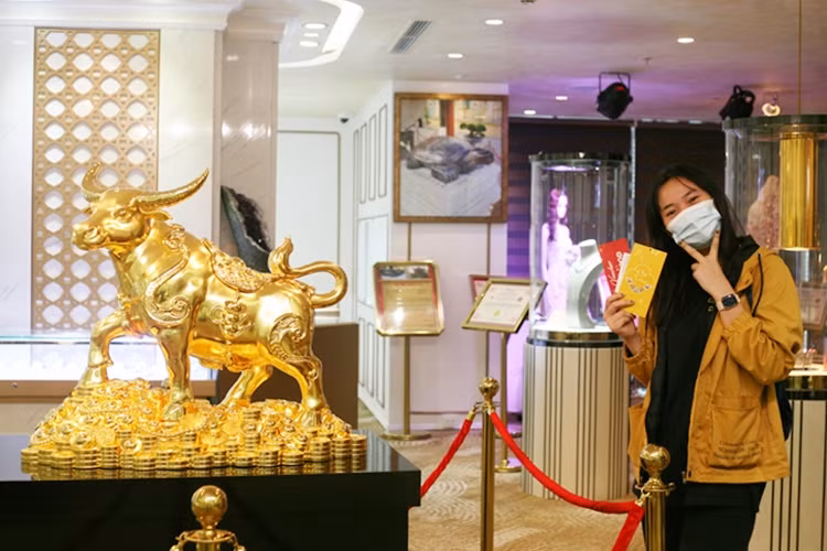 Nữ khách hàng không quên check-in cùng trâu vàng 999.9 nguyên khối nặng 20kg - Linh vật may mắn của năm mới.