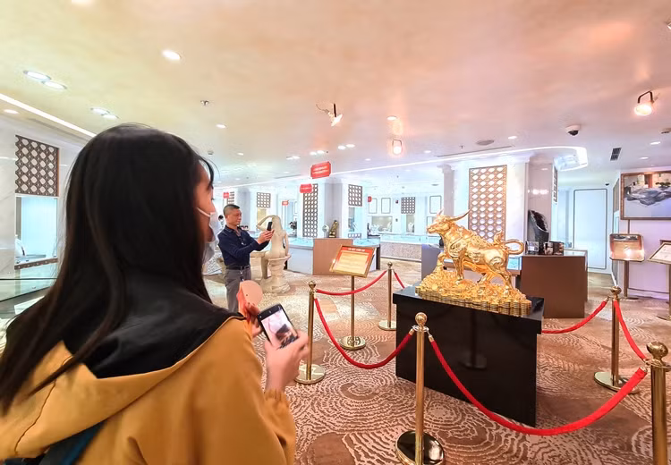 Nhiều khách hàng đến mua vàng trước Ngày vía Thần Tài ở DOJI Tower số 5 Lê Duẩn đều thích thú với sản phẩm trâu vàng nguyên khối nặng 20kg.