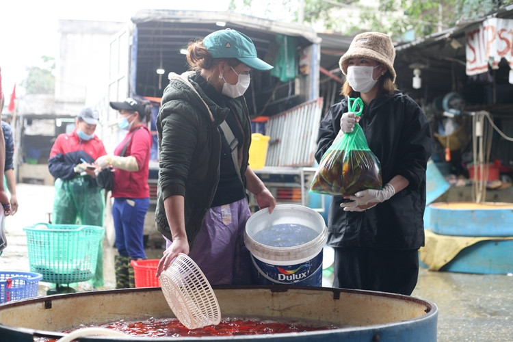 Để phòng, chống dịch bệnh COVID-19, hầu hết các tiều thương và một vài người dân khi đến chợ mua bán cá chép phóng sinh sớm đều tuân thủ việc đeo khẩu trang.