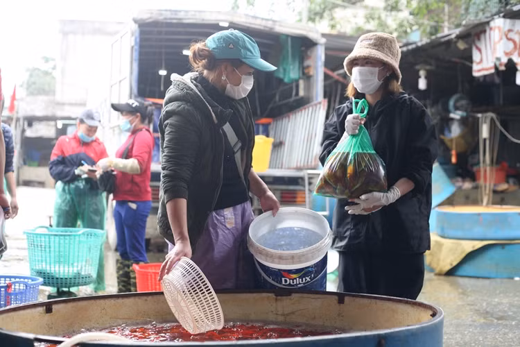 Để phòng, chống dịch bệnh COVID-19, hầu hết các tiều thương và một vài người dân khi đến chợ mua bán cá chép phóng sinh sớm đều tuân thủ việc đeo khẩu trang.